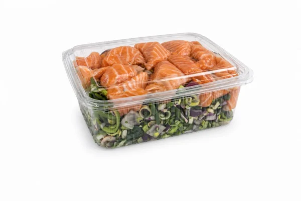 Roerbakgroente met zalm in een transparante bak op een witte studioachtergrond